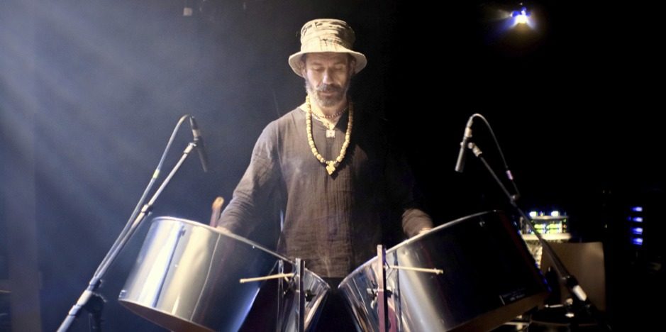 Mathieu Borgne au steeldrum, coiffé d’un chapeau, sous les projecteurs